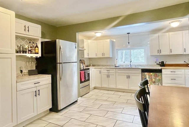 kitchen featuring stainless steel appliances, light countertops, white cabinets, and a sink