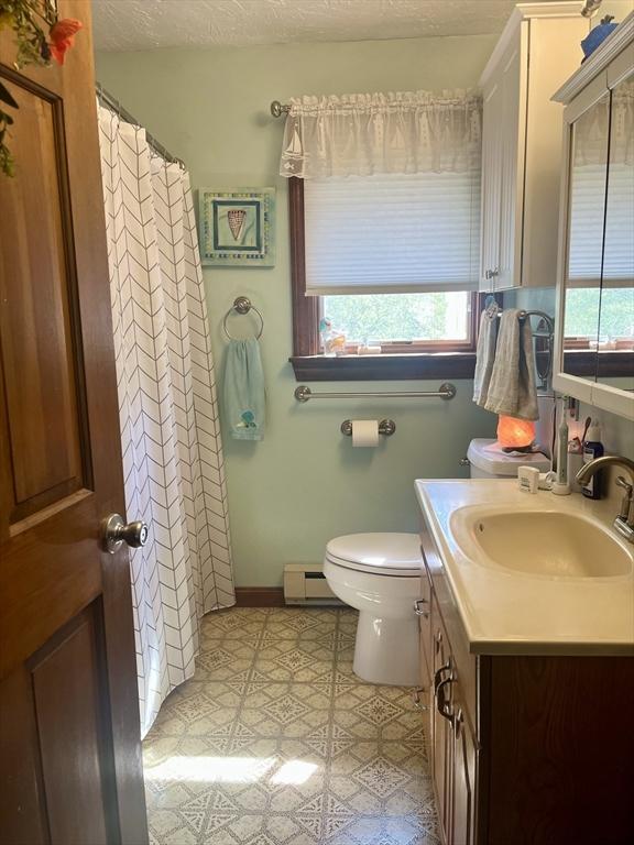 15 Old County Rd, Holland, MA 01521 - bathroom featuring toilet, plenty of natural light, baseboard heating, and vanity