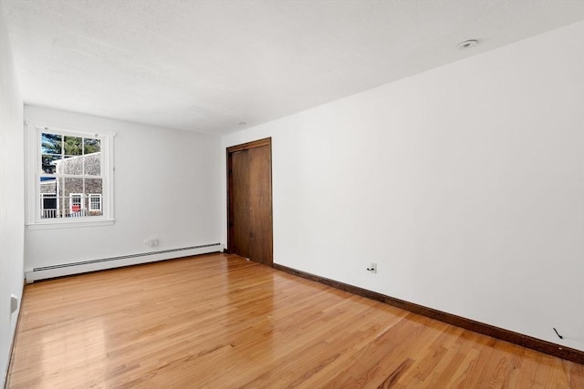 209 Pleasant, Millis, MA 02054 - spare room with a baseboard heating unit, light wood-style flooring, and baseboards