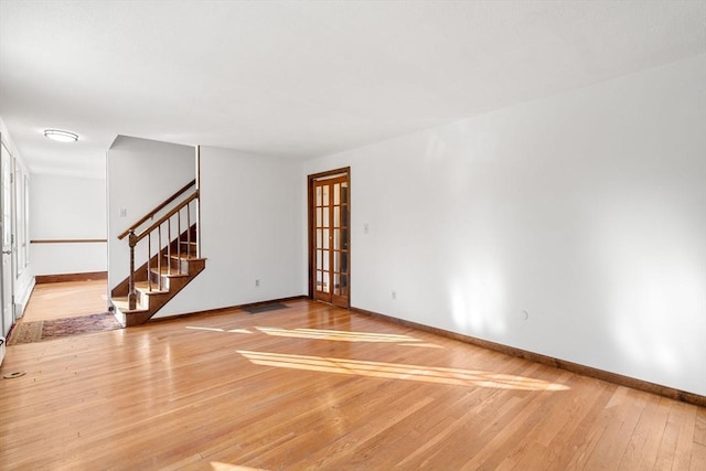 209 Pleasant, Millis, MA 02054 - unfurnished living room featuring stairs, light wood finished floors, and baseboards