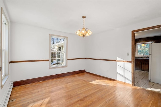 209 Pleasant, Millis, MA 02054 - spare room featuring a baseboard radiator, a chandelier, light wood-type flooring, a sink, and baseboards