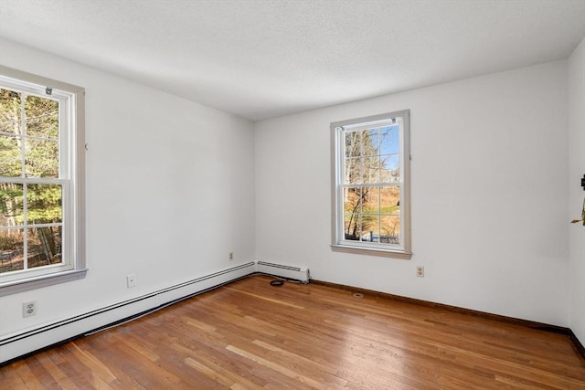 209 Pleasant, Millis, MA 02054 - empty room featuring baseboard heating, plenty of natural light, and wood finished floors