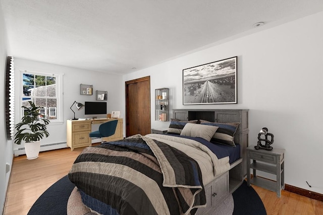 209 Pleasant, Millis, MA 02054 - bedroom with light wood-type flooring, a closet, a baseboard heating unit, and baseboards