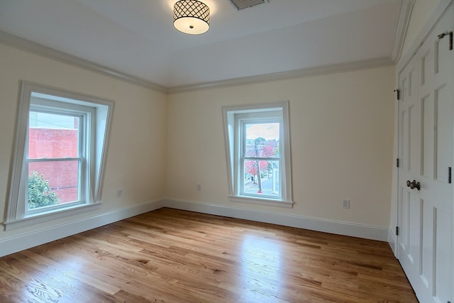 unfurnished bedroom with multiple windows, light hardwood / wood-style flooring, and ornamental molding