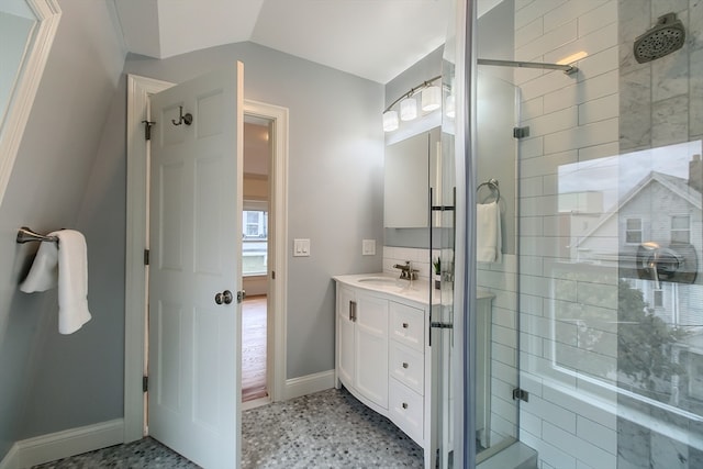 bathroom with walk in shower, tile patterned flooring, vaulted ceiling, and vanity