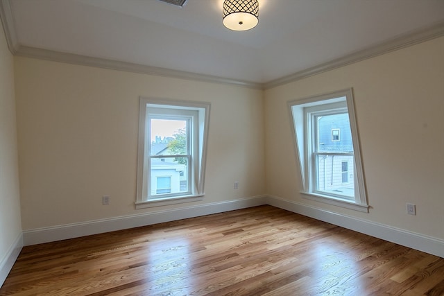 empty room featuring crown molding and light wood-type flooring