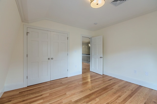 unfurnished bedroom featuring light hardwood / wood-style flooring, a closet, and ornamental molding