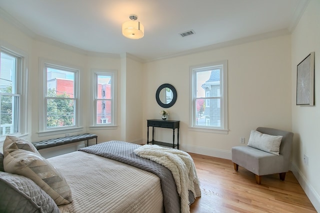 bedroom with light hardwood / wood-style flooring and crown molding