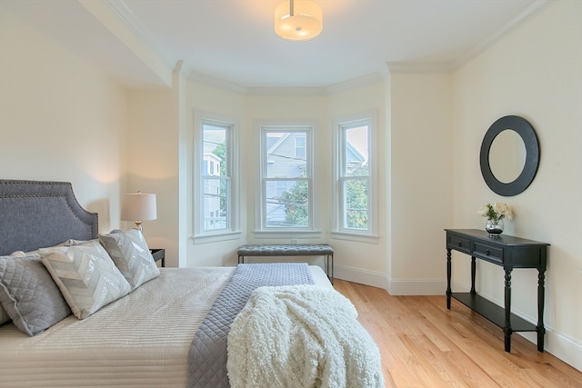 bedroom with light hardwood / wood-style floors and crown molding