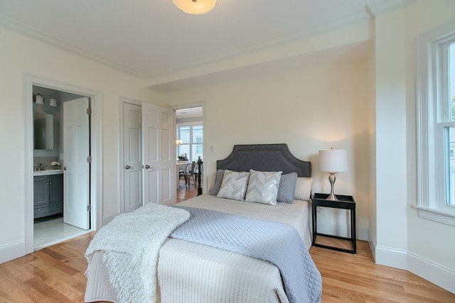 bedroom featuring light hardwood / wood-style flooring and connected bathroom