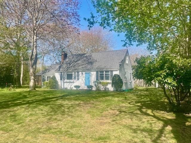 view of front of house featuring a chimney and a front yard