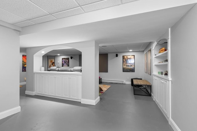 interior space featuring a paneled ceiling, baseboards, and a baseboard radiator