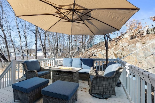 wooden deck featuring an outdoor living space with a fire pit