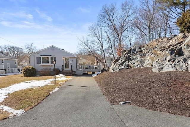 bungalow with aphalt driveway and fence