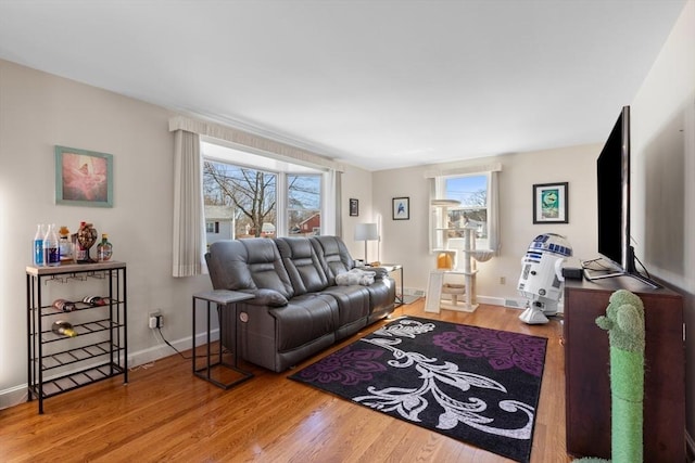 living area with baseboards and wood finished floors