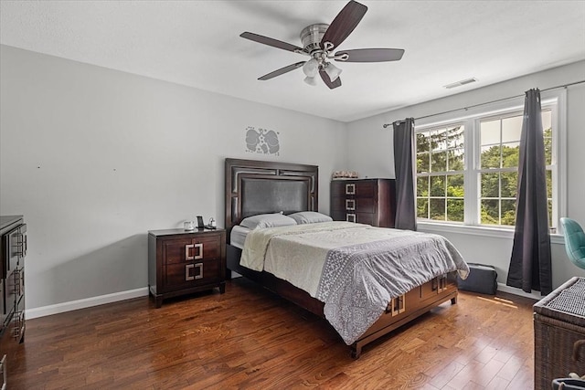 bedroom featuring visible vents, a ceiling fan, baseboards, and wood finished floors
