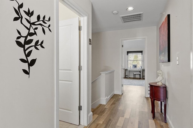 corridor with baseboards, visible vents, recessed lighting, an upstairs landing, and light wood-type flooring