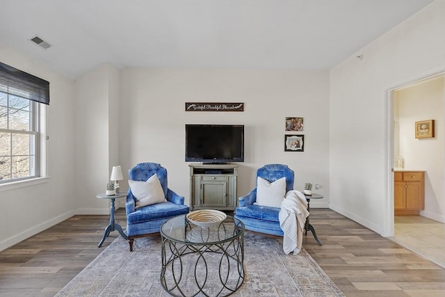 sitting room with visible vents, light wood-type flooring, and baseboards