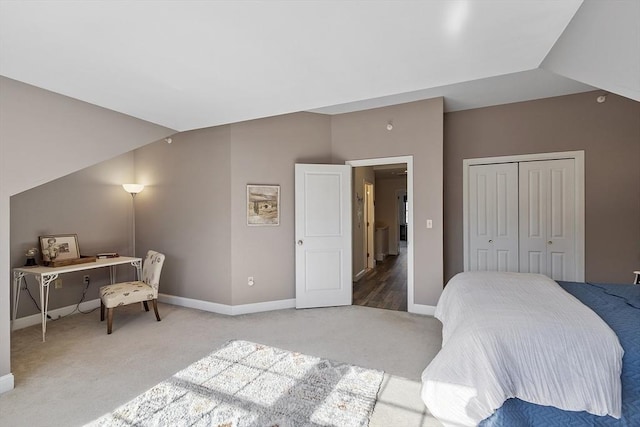 bedroom with lofted ceiling, carpet, baseboards, and a closet