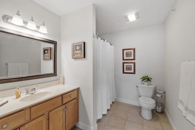 bathroom with tile patterned flooring, toilet, vanity, and baseboards