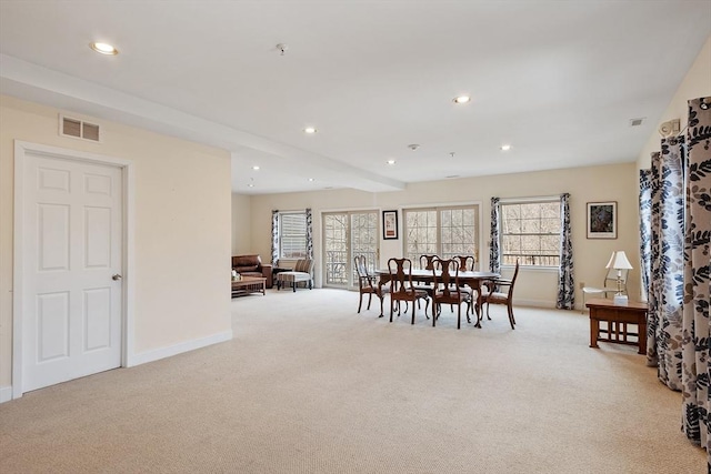 dining room featuring recessed lighting, plenty of natural light, light colored carpet, and visible vents