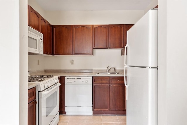 kitchen with white appliances, light tile patterned flooring, light countertops, and a sink