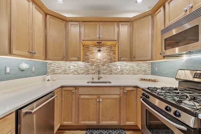 kitchen featuring tasteful backsplash, light countertops, recessed lighting, stainless steel appliances, and a sink