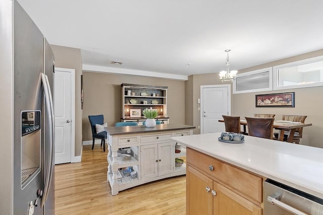 kitchen featuring visible vents, appliances with stainless steel finishes, pendant lighting, light wood-type flooring, and a chandelier