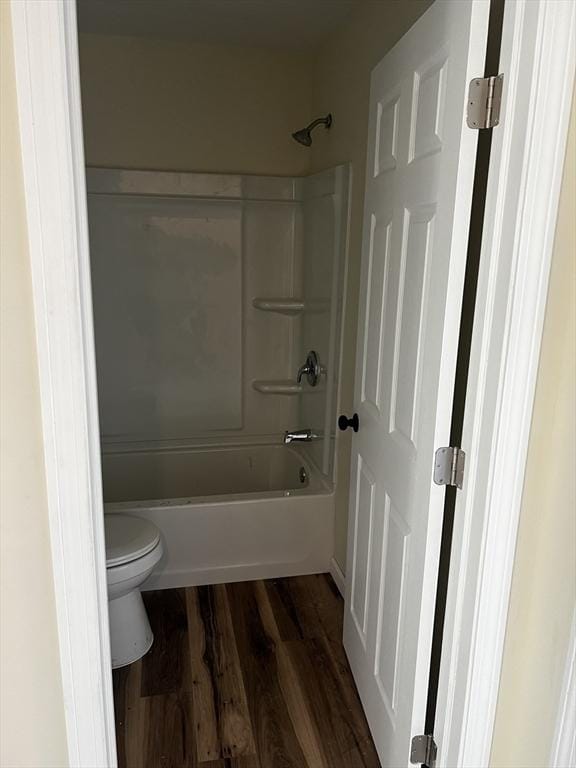 bathroom featuring toilet, wood-type flooring, and  shower combination