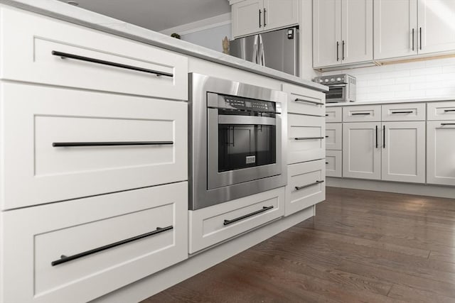 kitchen featuring dark wood finished floors, decorative backsplash, and light countertops