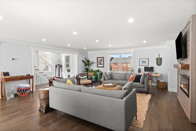 living room with stairs, ornamental molding, recessed lighting, a fireplace, and dark wood-style flooring