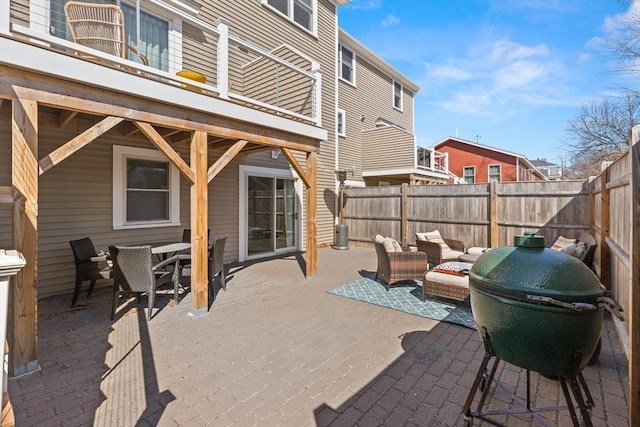 view of patio / terrace featuring a grill, outdoor dining area, a fenced backyard, and an outdoor hangout area