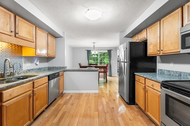 18 Hitching Post Ln Unit 18, Northborough, MA 01532 - kitchen featuring stainless steel appliances, light wood finished floors, light stone countertops, backsplash, and hanging light fixtures