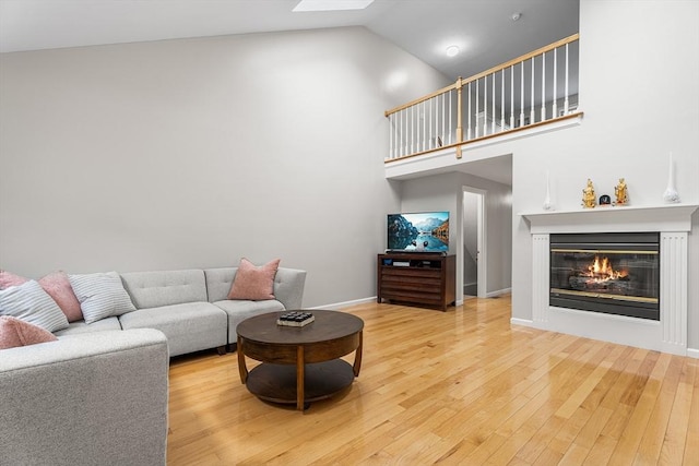 18 Hitching Post Ln Unit 18, Northborough, MA 01532 - living room featuring high vaulted ceiling, wood finished floors, a glass covered fireplace, and a skylight