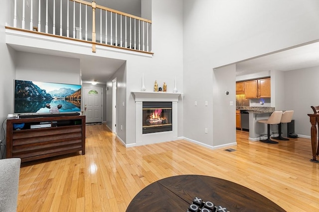 18 Hitching Post Ln Unit 18, Northborough, MA 01532 - living area featuring light wood finished floors, a high ceiling, and a glass covered fireplace