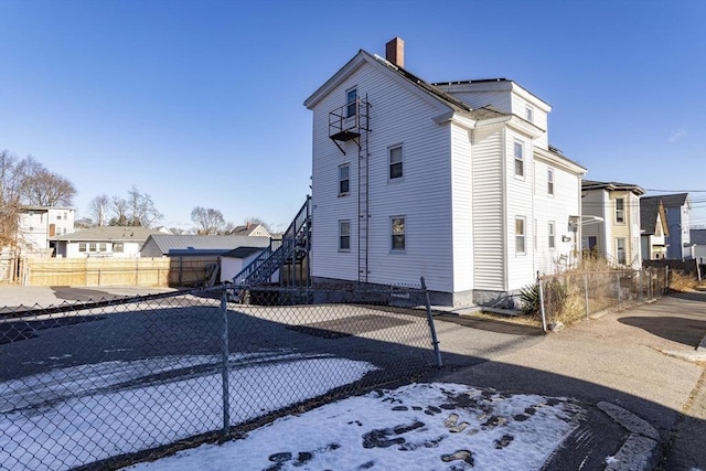 43 Huntington St, Brockton, MA 02301 - view of snow covered exterior with a chimney