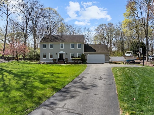 colonial-style house with a garage, driveway, and a front yard