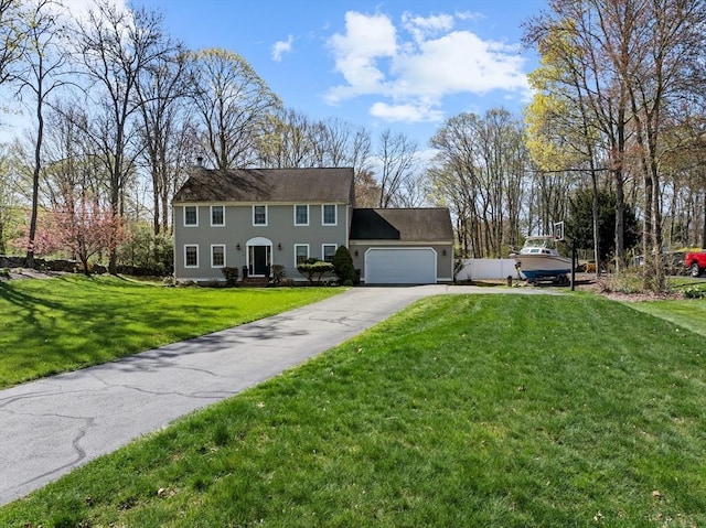 colonial home featuring aphalt driveway, a front lawn, and a garage