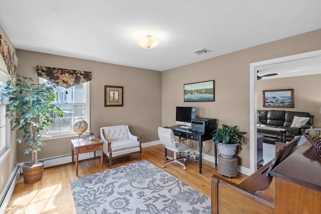 office area featuring baseboards, visible vents, wood finished floors, and a baseboard radiator