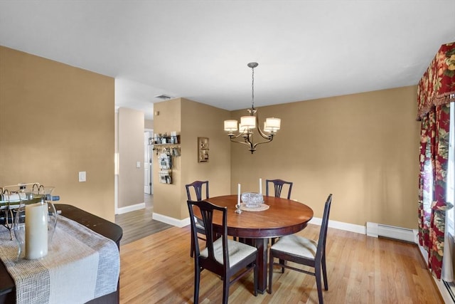 dining room with a notable chandelier, baseboards, light wood-type flooring, a baseboard radiator, and visible vents