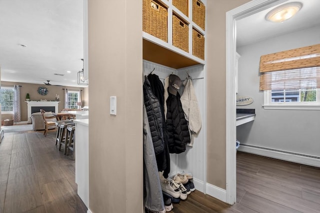 mudroom featuring a fireplace, baseboards, baseboard heating, and dark wood-type flooring