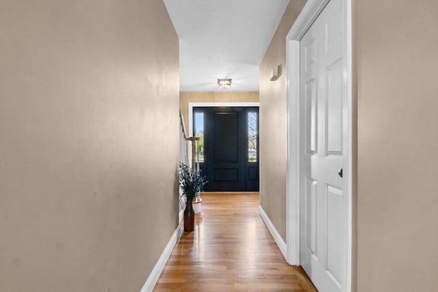 hall with baseboards and wood finished floors