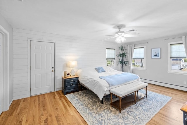 bedroom with visible vents, a baseboard radiator, light wood finished floors, and ceiling fan