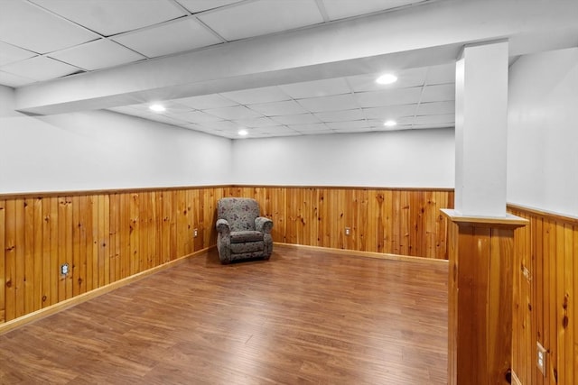 unfurnished room with a paneled ceiling, wainscoting, wood walls, wood finished floors, and recessed lighting