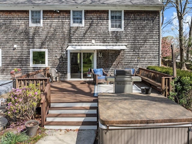 back of property featuring a hot tub and a deck