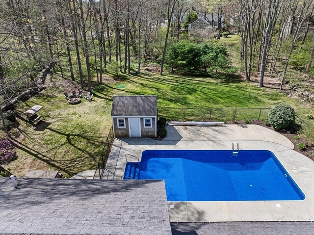 view of pool featuring an outbuilding, fence, a fenced in pool, a yard, and a patio