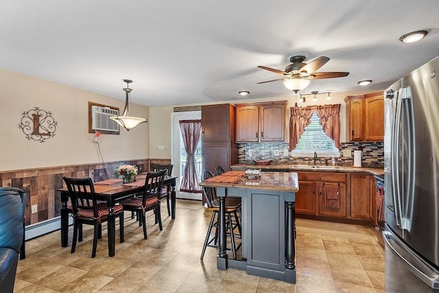 68 Victoria Ave, Athol, MA 01331 - kitchen featuring freestanding refrigerator, an AC wall unit, a ceiling fan, a breakfast bar area, and a center island