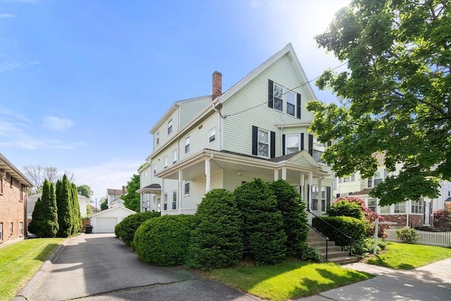 247 Ash St Unit 3, Waltham, MA 02453 - view of front facade with a chimney, an outbuilding, and a garage