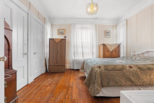 bedroom with a notable chandelier and wood finished floors