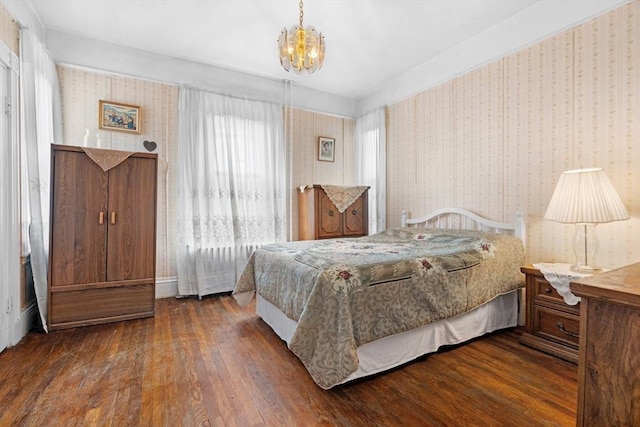 bedroom with an inviting chandelier, wood finished floors, and wallpapered walls